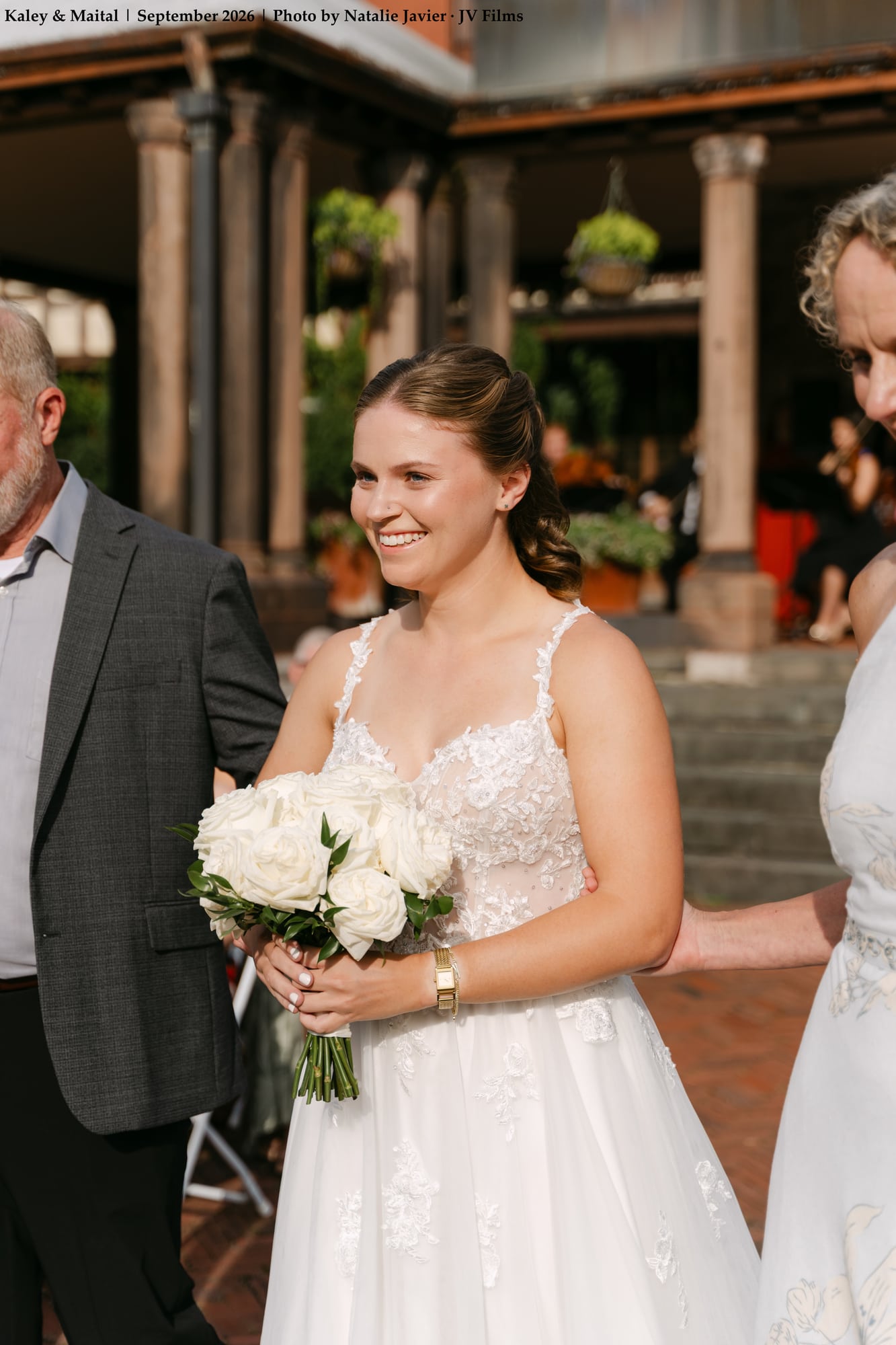 Bride smiling walking down ceremony aisle path with father