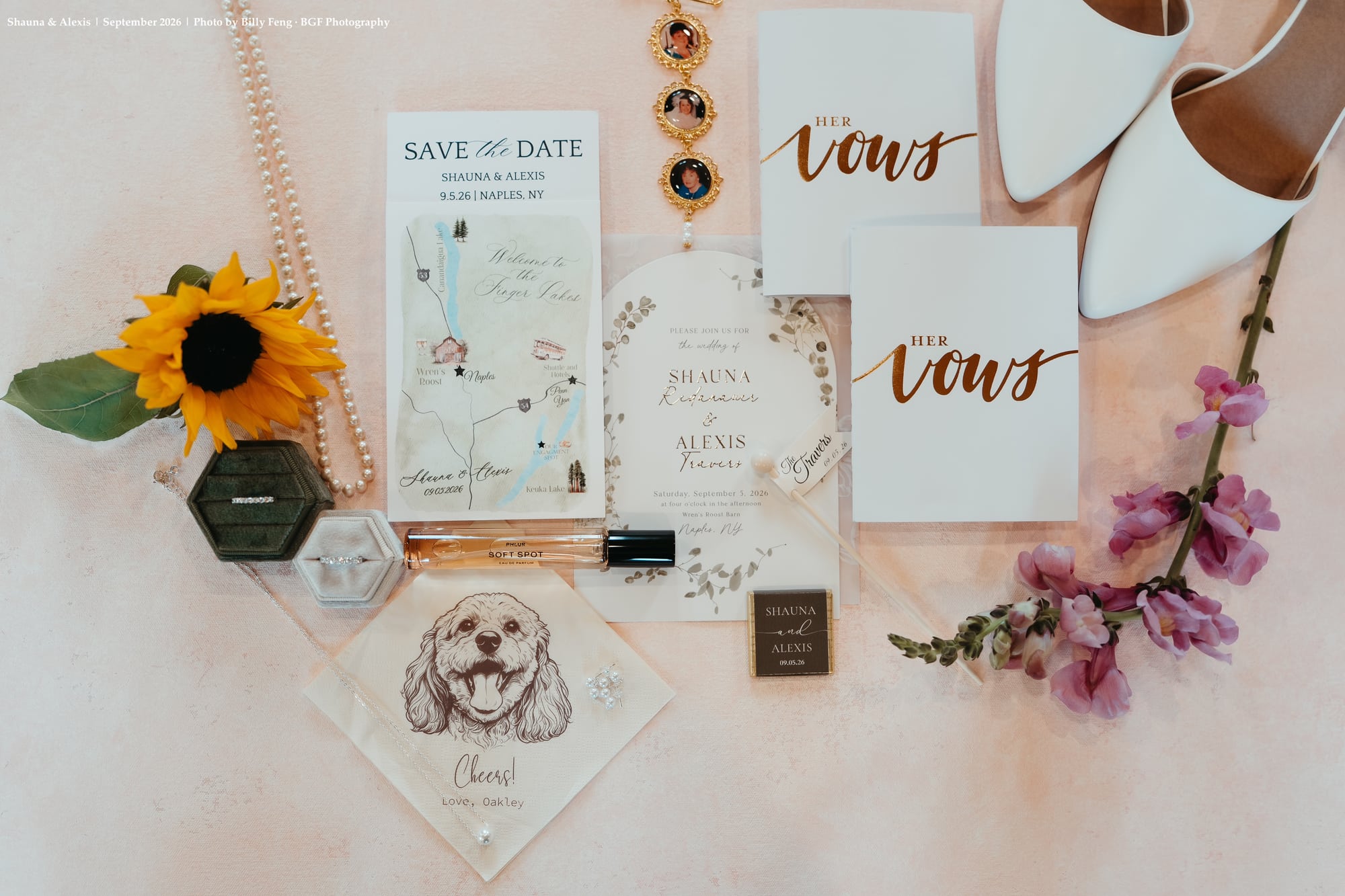 Custom wedding invitation suite, vows book, and rings flatlay