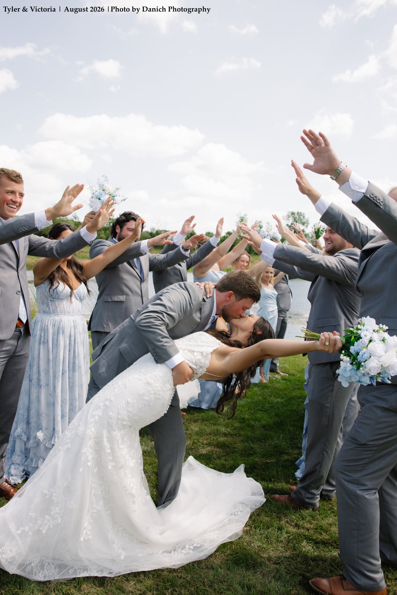 Bridal party cheering during joyous dip kiss